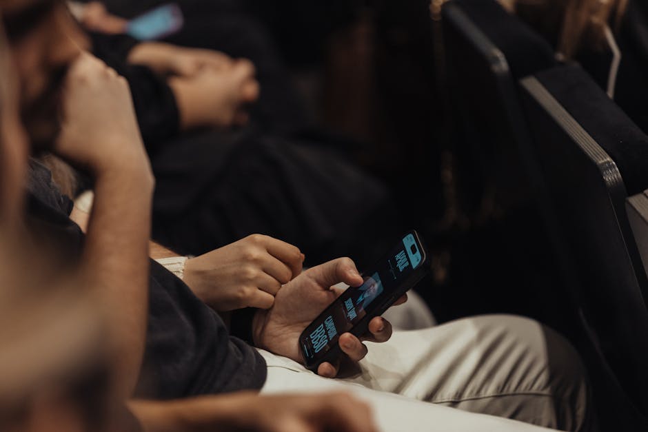 People attending a conference using smartphones, showcasing modern technology engagement.