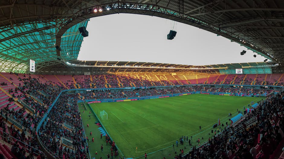 Panoramic view of a bustling soccer stadium filled with enthusiastic fans during a vibrant match.